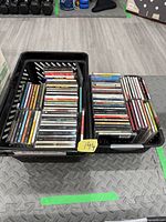 Two baskets containing stacks of CDs in jewel cases and digipaks