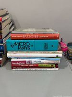Stack of eight cookbooks showing titles and spines