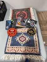 Two stacked hooked rugs, five CDs, two patches