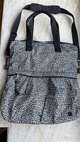Front view of Lululemon black & white pebble-print tote with handles and shoulder strap