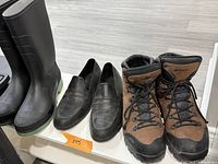 All three pairs side by side: rain boots, slip-on shoes, hiking boots