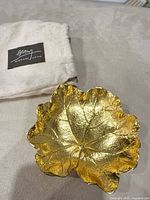 Gold leaf-shaped dish with pouch visible