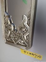 Close-up of ornate silver frame and intact glass