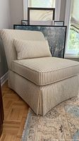 Left side view of chair showing striped upholstery, skirt, and pillow
