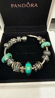 Closed Pandora box displaying sterling silver charm bracelet with assorted charms