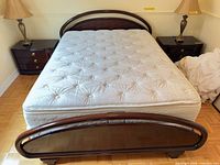 Full view of queen bed frame with mattress and matching nightstands