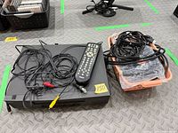 Front view of RCA VCR with remote and cables on top