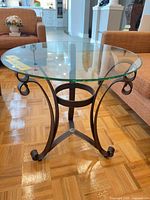 Full view round glass top side table with metal base