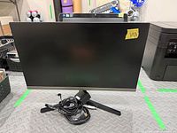 Front view of Samsung monitor on stand with cables