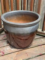 Two-tone glazed ceramic planter exterior on deck