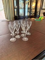 Eight clear stemmed cordial glasses on table