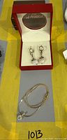 Earrings in red box and necklace coiled below