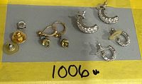Overview of all earrings and spare backs on grey board