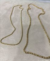 Both necklaces laid flat showing difference in gauge