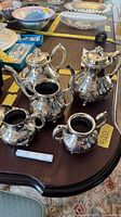 Full view of the five silver-plated vessels on tabletop
