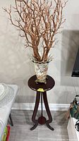 Full view of vase on stand with branches