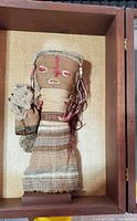 full view of burial doll inside case