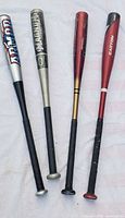 Group shot of four aluminum baseball bats standing upright