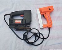 Top view of jigsaw and stapler with cords visible