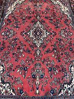 Full view of rug showing red field, central medallion, floral motifs