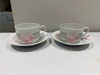 Set of two Hermès Les Pivoines cups with saucers