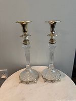 Full view of both matching crystal and silver-plated candlesticks on tabletop