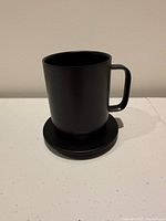 Black Ember Smart Mug 2 on charging coaster, front view