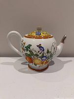 Right side view of Hermès La Siesta teapot showing floral motif, handle, spout and lid