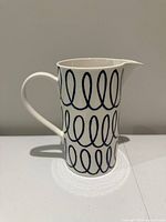Full left-front view of pitcher showing loop pattern and handle