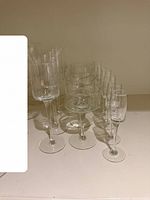 Group view of all 16 stemmed glasses: flutes in front, coupes in middle, liqueur glasses at back