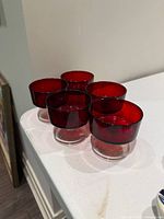 five ruby red dessert glasses grouped on countertop