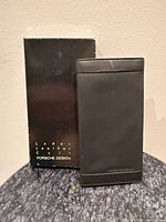 Wallet standing in front of original box showing front exterior and embossed logo