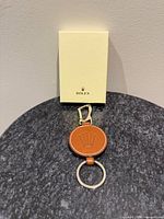 Front view of brown leather Rolex key ring and box
