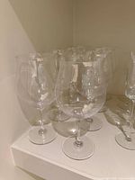 group of clear wine glasses on shelf