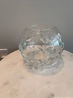 Front view of round crystal vase showing floral vine cuts