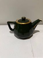 Right side view of green porcelain teapot with gold trim