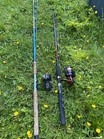 Full view of both fishing rods with reels on grass