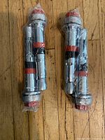 Two shrink-wrapped steel wedge anchors with red caps