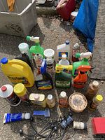 Group of automotive fluids, cleaners, polishes and trailer hitch balls on ground