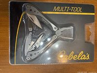 Front of sealed retail blister pack showing Cabela's multi-tool