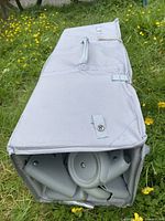 Folded playpen inside gray fabric case showing wheels and frame