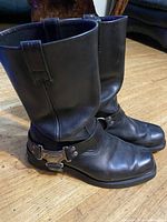 Side view of both boots showing leather condition, harness strap and logo hardware