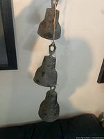 Three cast brass bells hanging on rope