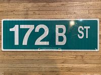 Front view of green reflective street sign reading 172 B ST showing condition and mounting holes