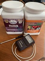 Front view of both fertilizer tubs and soil pH meter with probe