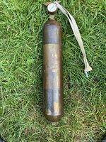 Full view of brass cylinder extinguisher on grass