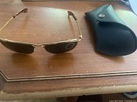 Sunglasses folded beside case on table
