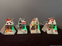 Front view of all four illuminated Hallmark Caroling Cottages
