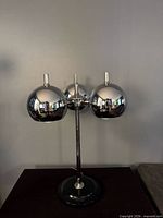 Full lamp front view showing three chrome orb shades and base