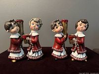 All four ceramic caroler candle holder figurines front view